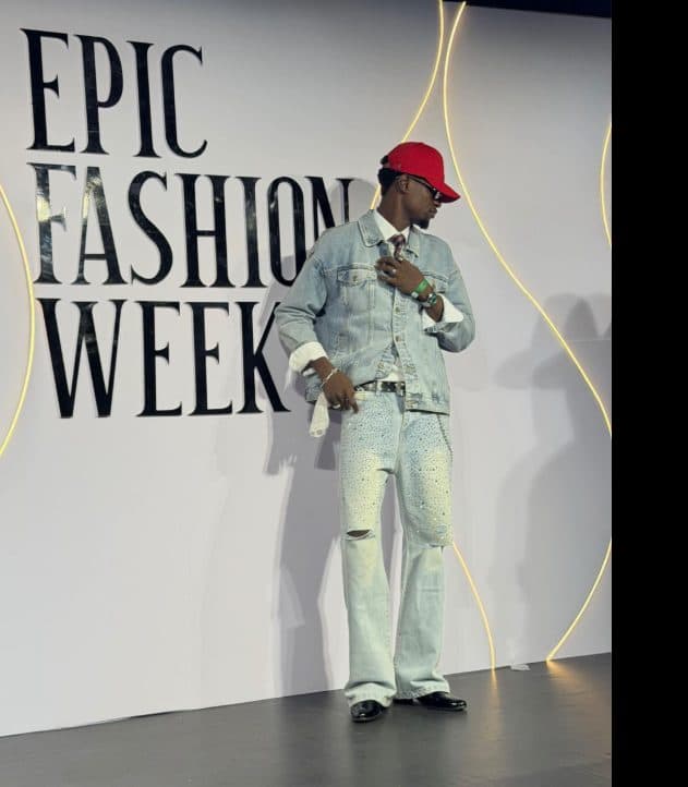 Pale denim two-piece and red cap on the Epic Fashion Week set