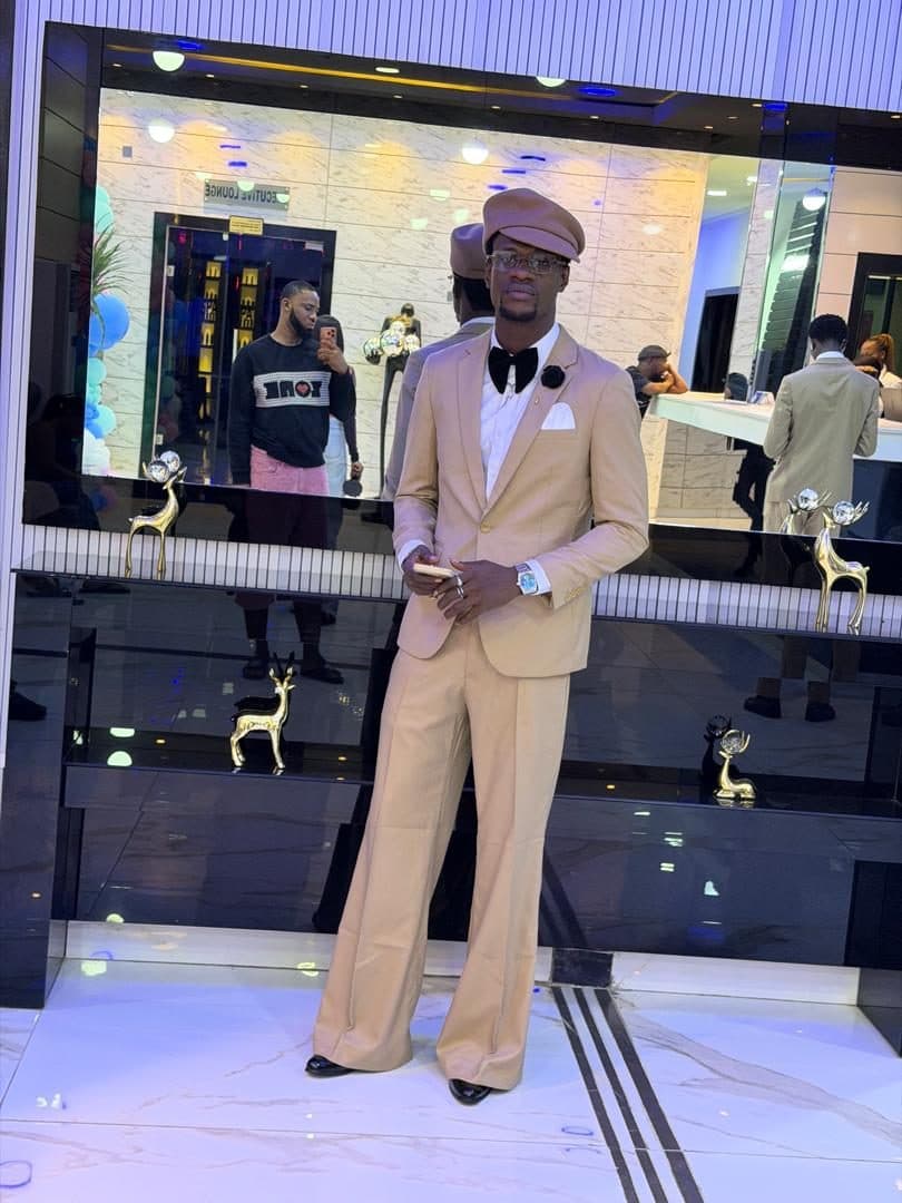 Tan single-breasted suit with a bow tie and matching cap